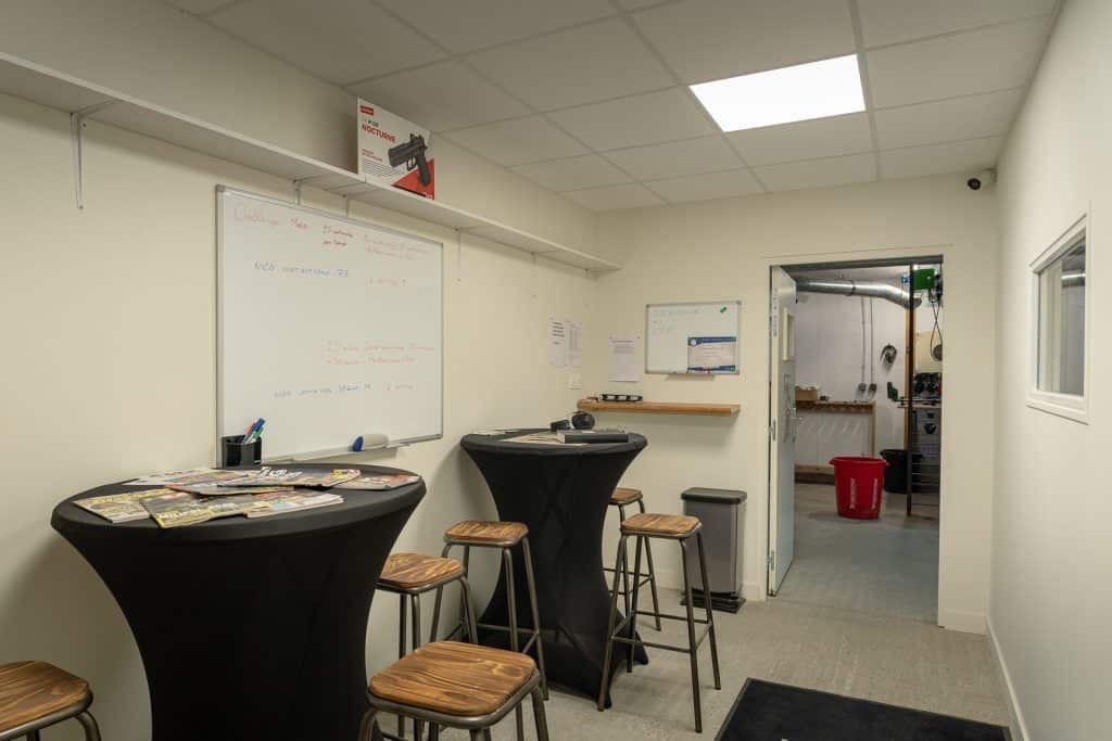 Club house du Club de Tir Plaintelais avec tables hautes et tableau